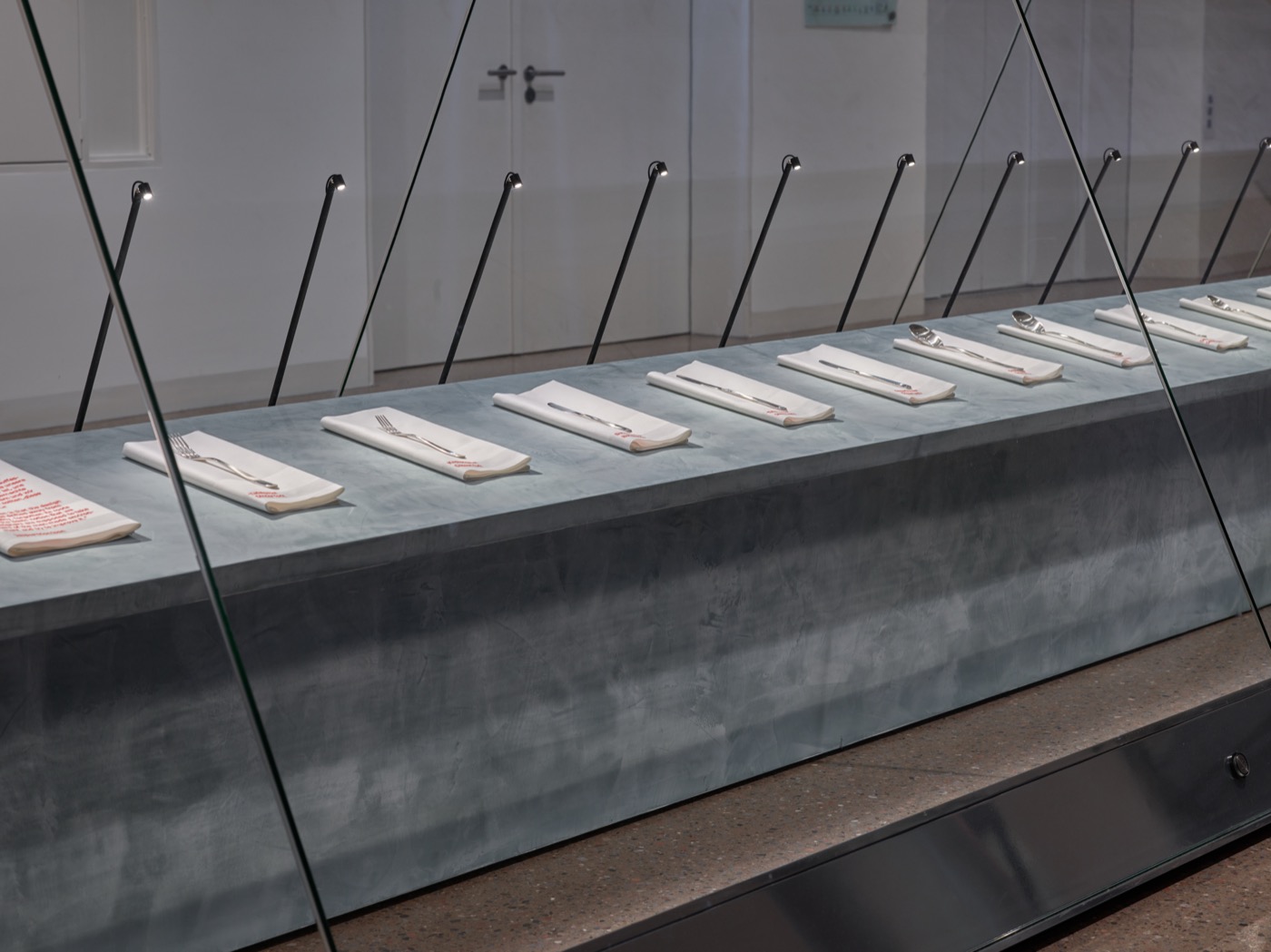 Design Display, Detailbild Vitrine mit Podest, Servietten und Besteck beleuchtet zur zweiten Ausstellung Simplicity